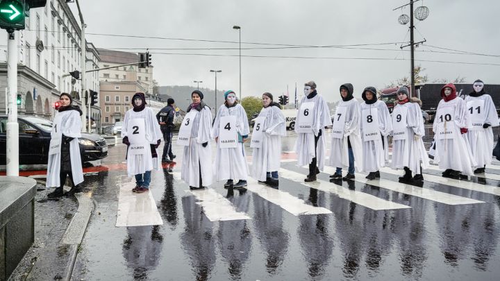 Bündnis 8. März Weiß gekleidete Personen mit weißen Masken und einer Zahl an der Brust, die die Anzahl an Femiziden im Jahr 2023 widerspiegelt
