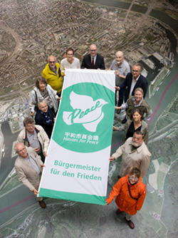 Foto der Mitglieder der Friedensinitiative mit Bürgermeister Prammer und der Flagge der Mayors for Peace
