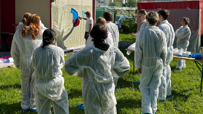 Foto: Privat Eine Gruppe von Jugendlichen, die mit dem Graffiti-Künstler auf eine Leinwand sprühen.