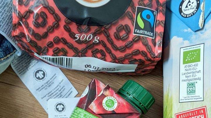 verschiedene Produktverpackungen mit den Gütesiegeln Fairtrade, EU-Biosiegel, Bio Austria, GOTS