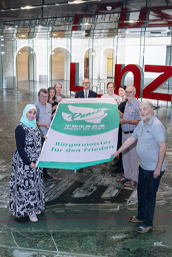 Foto der Mitglieder der Friedensinitiative mit Bürgermeister Prammer und der Flagge der Mayors for Peace