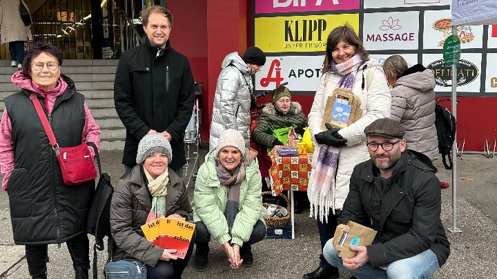 Frauenbüro Linz Mehrere Menschen mit Informationsmaterialien vor dem Einkaufszentrum Auwiesen