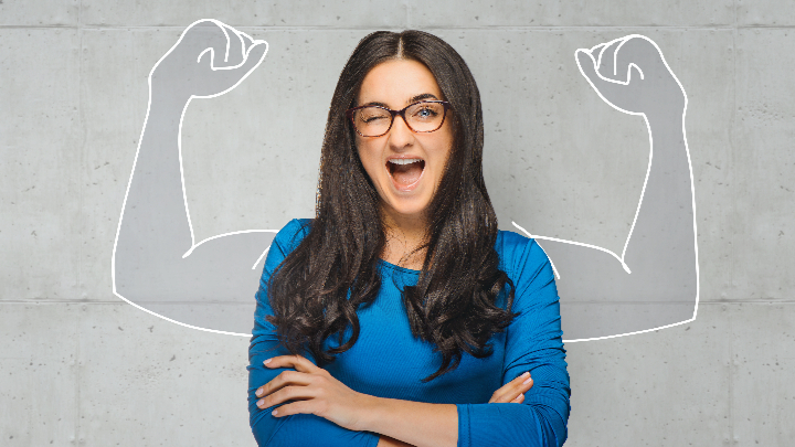 Frau mit langen dunklen Haaren in blauem Oberteil steht mit verschränkten Armen vor weißem Hintergrund mit gezeichneten, nach oben gestreckten Muskeln an beiden Seiten