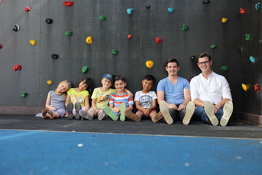 Foto: MagArt.GregorHartl Leiter eines Hortes mit Kindergruppe vor einer Kletterwand