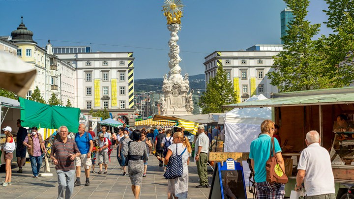 Reges Treiben am Stadtmarkt Hauptplatz, im Hintergrund die Dreifaltigkeitssäule