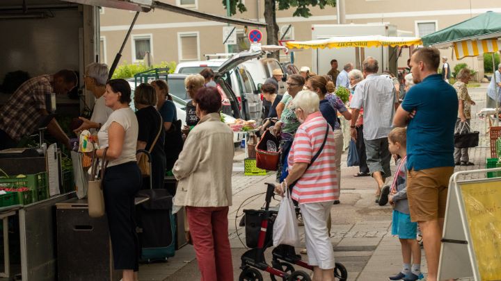 Wartende Marktkunden vor Marktstand