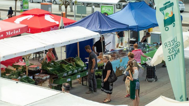 Wartende Kunden vor Marktständen