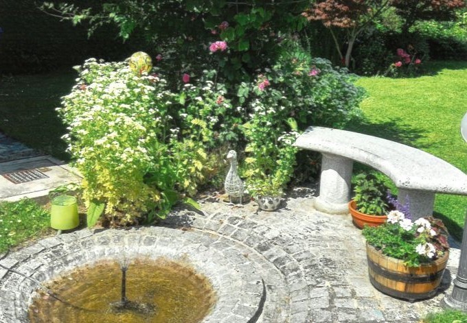 Carmen Nirnberger Sitzplatz mit Wasserstelle und blühenden Stauden