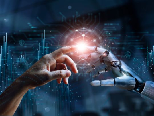 Menschenhand und Roboterhand, die sich an den Fingern berühren