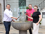 Personengruppe beim Brunnen