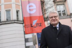 Bürgermeister Klaus Luger vor der neuen Friedensfahne, die vor dem Alten Rathaus ein weithin sichtbares Zeichen für den Frieden setzt.